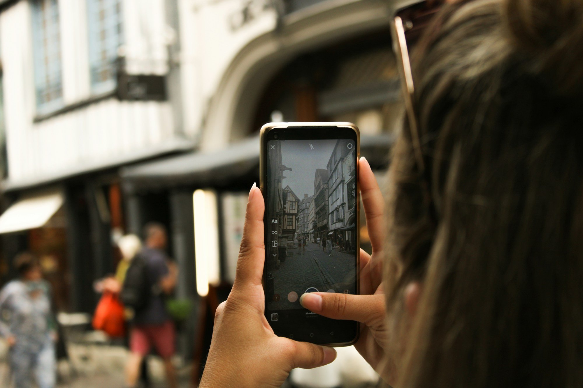 Smartphone in der Hand auf einer belebten Straße